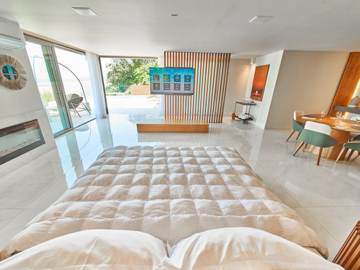 Suíte espaçosa no VIP’s Suítes com cama king e janelas para o oceano, padrão Melhores Motéis de Luxo no Rio de Janeiro